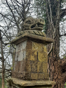 A stone pilar with a stylised boar's head at the top.