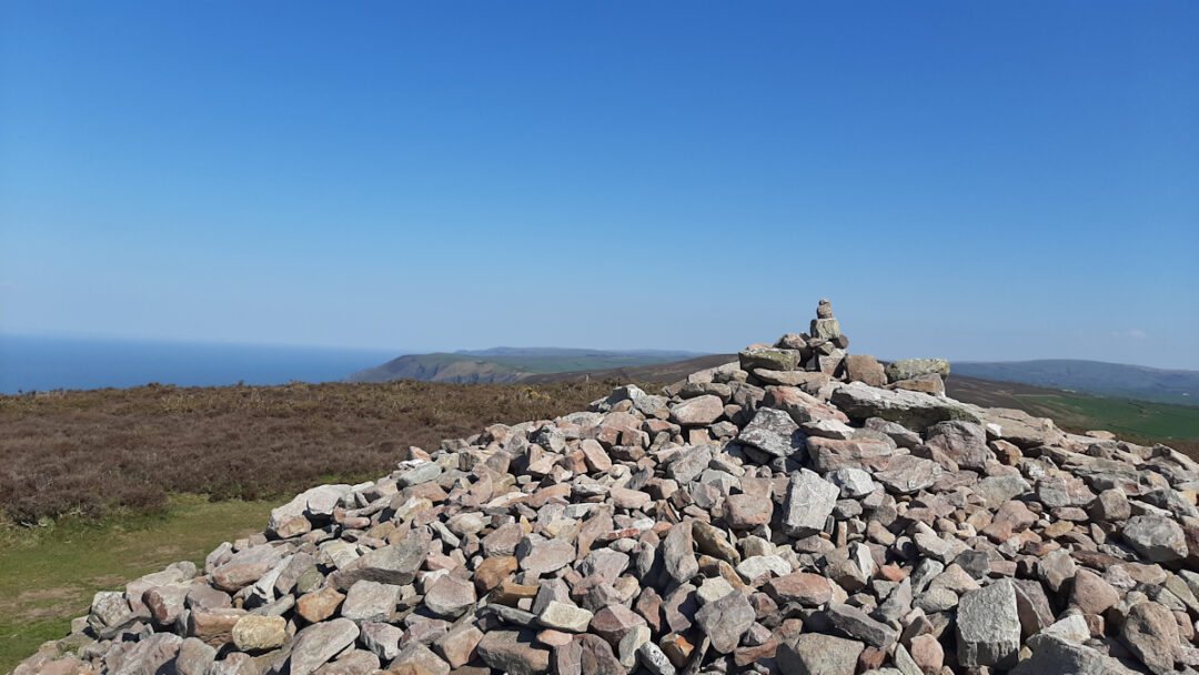 A sprawling pile of stones with flat-topped hills in the distance