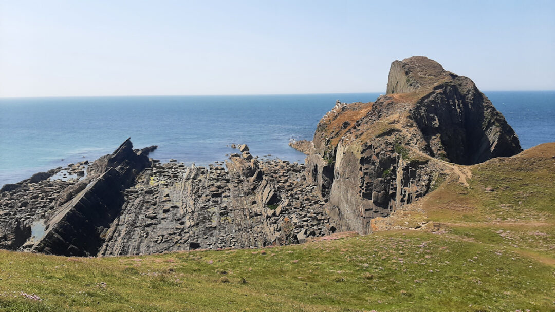 A rocky shore framed by vertical rock walls at either side.