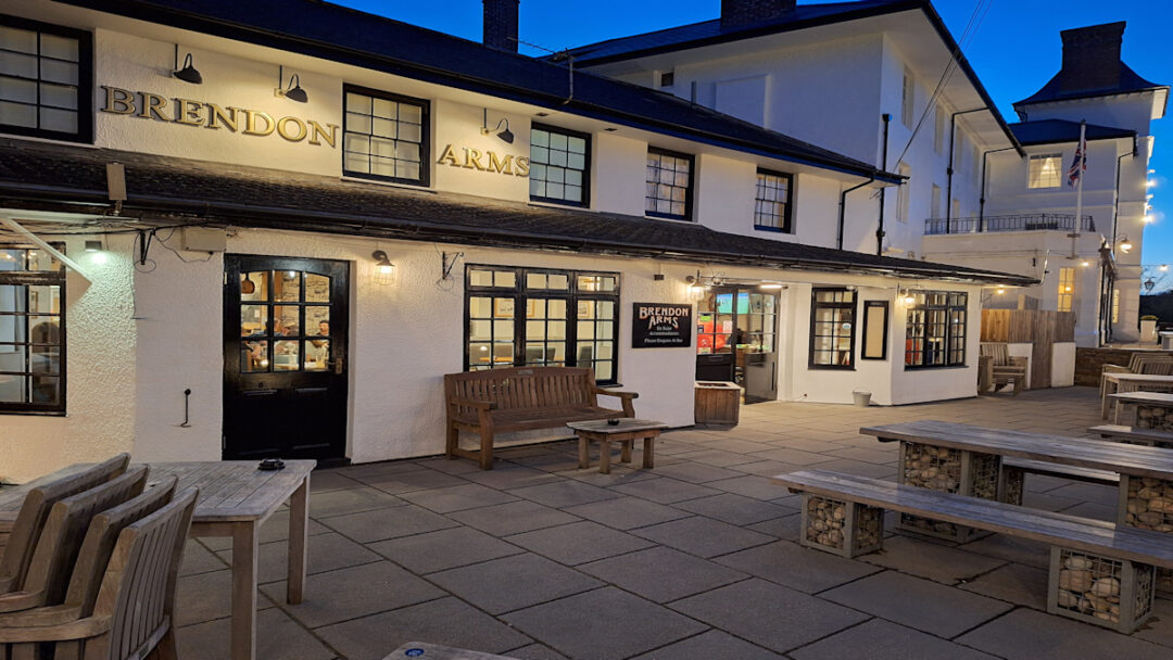 A low two-storey building with soft evening lighting and the words "Brendon Arms"