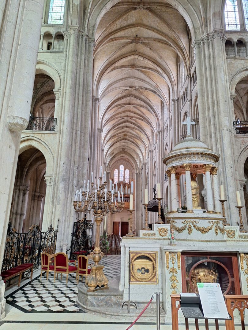 The nave of a Gothic cathedral with soaring columns and a vaulted ceiling. It is light, and sparsely decorated.